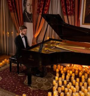 一位西装革履的男士站在钢琴旁