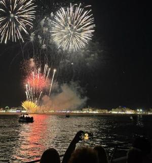 a group of people watching fireworks in the water