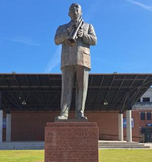 a statue of a man standing in front of a building