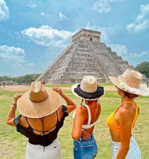 三个戴着帽子的女人看着金字塔