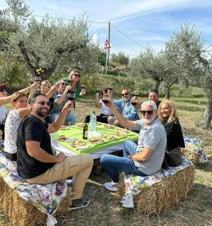 un gruppo di persone sedute attorno a un tavolo su balle di fieno