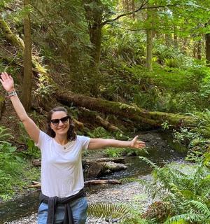 一位妇女站在森林里,双臂高举