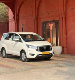 一辆白色汽车停在一栋红色建筑前