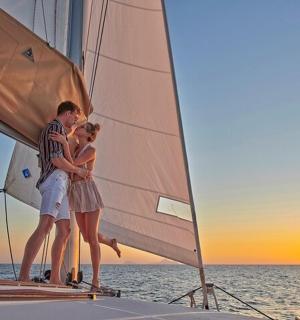 a group of people standing on a sailboat