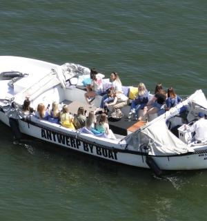 a group of people sitting on a boat in the water