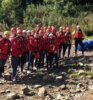 一群穿着红色夹克的人站在河边