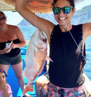 船上抱着鱼的女人