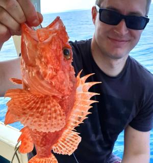 一个男人手里拿着一条大鱼