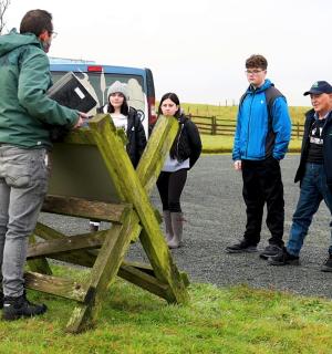 skupina lidí stojící vedle plotu