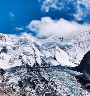 一座白雪皑皑的山峰,山顶上有两个人