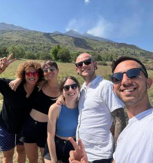 skupina lidí pózujících pro fotografii s horami v pozadí