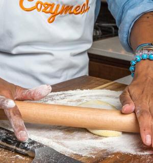 a person making a dough on a wooden table