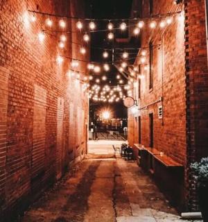 an alley way with lights and a brick building