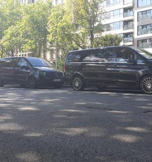 two black vans parked next to each other on a street