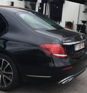 černé auto je zaparkované na příjezdové cestě