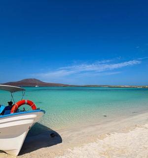 a boat sitting on a beach next to the water