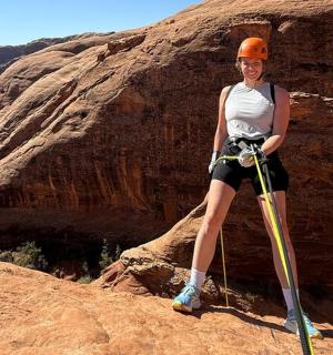 a woman is standing on top of a rock
