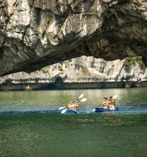 a group of people in kayaks in the water under a cave