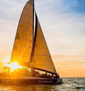 żaglówka na oceanie z zachodzącym słońcem