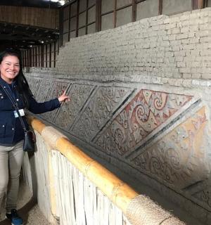 a woman standing next to a brick wall