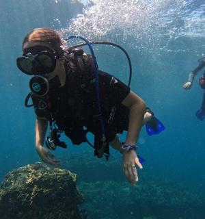 dua orang sedang menyelam skuba di dalam air