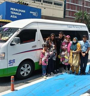 skupina lidí stojících před dodávkou