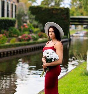 一位身穿红裙子的女子手捧一束鲜花