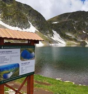 et fortolkningsskilt foran en bjergsø