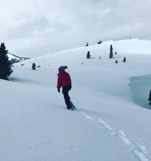 a person standing in the snow on a snow covered slope