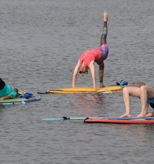 一群人站在水中的冲浪板上