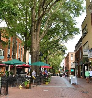 a street with tables and umbrellas on a city street