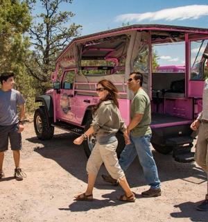 a group of people standing around a pink truck
