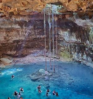 一群人在山洞里的水池里游泳