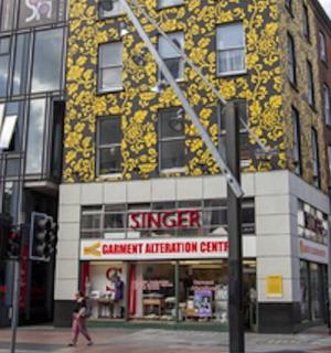 a building on a street with people walking in front of it