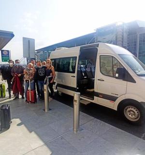 a group of people standing next to a white van