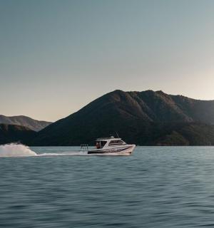 loď na vodě s horami v pozadí