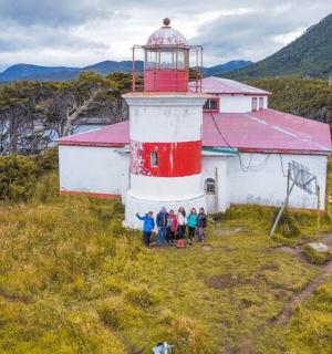 一群人站在红白相间的灯塔前