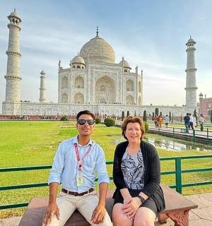 一男一女坐在一栋建筑前的长椅上