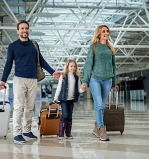 eine Familie, die mit ihrem Gepäck durch einen Flughafen geht