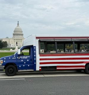 a red white and blue bus with the capitol building