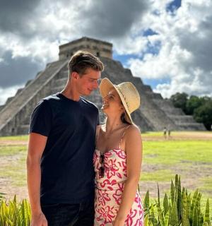 a man and a woman standing in front of a pyramid