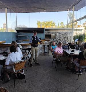 一名男子站在餐厅里,其他人则坐在桌旁