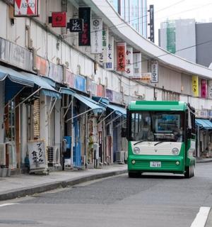 一辆绿白相间的巴士行驶在城市街道上