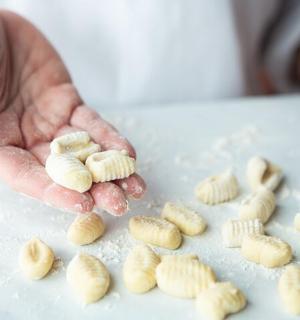 a hand holding up a bunch of pasta