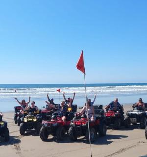 a group of people on quad bikes on the beach