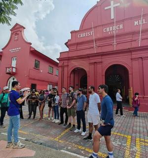 a group of people standing in front of a red building