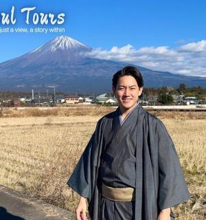 一位身穿和服的男子站在山前