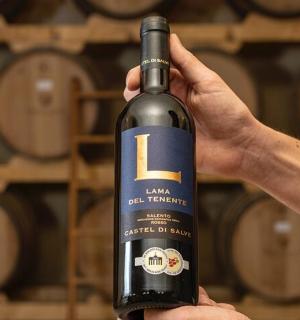 a person holding up a bottle of wine