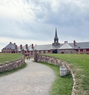 a large brick building with a church in the background