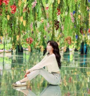 a woman sitting on the floor in front of flowers